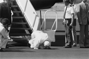 John Paul II kisses Polish soil during his first return to his country, 1979.