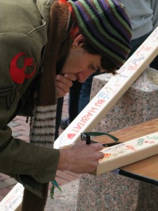 A BU student takes time to sign the board