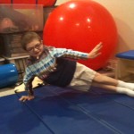 Ben demonstrating side plank in his basement therapy room