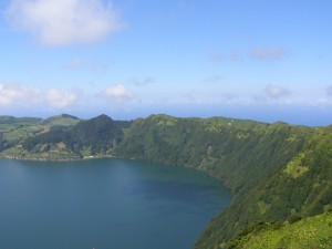 The lake in the crater is at the forefront, the ocean behind the rim.