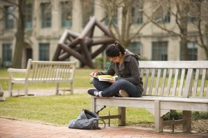 Julie Tran (SED, '13) relaxes near BU Beach to read "How to Find a Habitable Planet" for her Alien World Astronomy class on March 18, 2011.