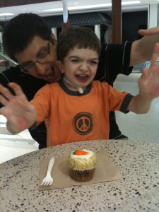 Ben celebrating 12 years with his favorite carrot cake (and dad)
