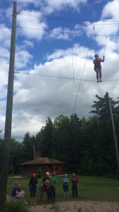 Resident Assistant Mackenzie Newell receives advice and encouragement from her fellow RA’s as she tackles a high ropes challenge. 